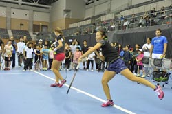 テニスクリニックでサーブのお手本を見せる田中優季選手とセニア・リキーナ選手