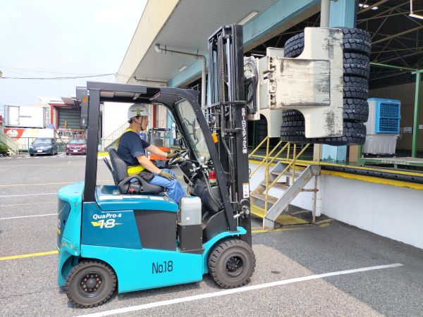クランプリフトを使ってタイヤを運ぶ様子